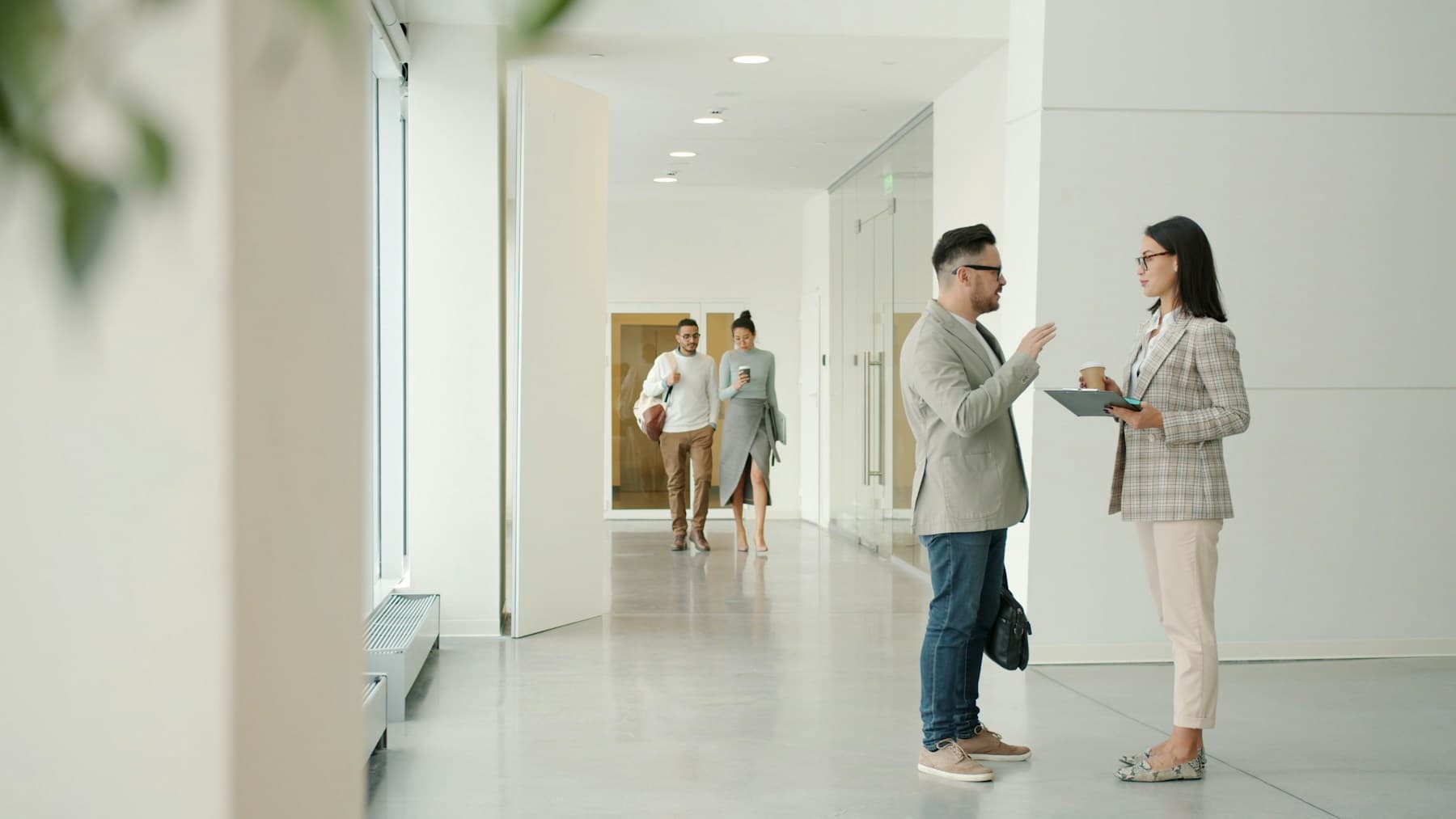 Two colleagues in a calm, focused conversation in a bright office